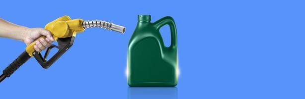 Hands holding Fuel nozzle and bottle of engine oil on blue background photo