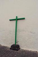 A green wooden cross on the street based on an old white house on the island of Lanzarote photo