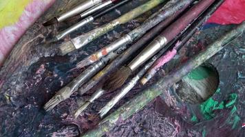 Used brushes on an artist's palette of colorful oil paint photo