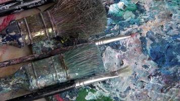 Used brushes on an artist's palette of colorful oil paint photo