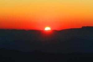 Sunset in sky and cloud, beautiful colorful twilight time with silhouette of mountain. photo