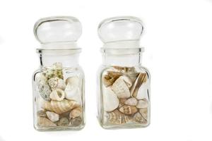 a glass container full of shells on a white isolated background photo