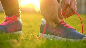 Running shoes - woman tying shoe laces. Slow motion video