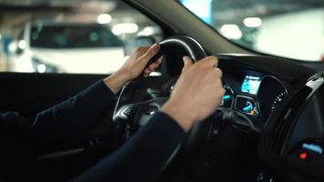 hombre conducción coche mediante un estacionamiento lote y es mirando para un sitio a parque o conducción lejos video