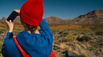 aktiva vandrare kvinna vandring på teide nationell parkera och gör Foto landskap på de smartphone. teneriffa, kanariefågel öar video