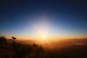 hermosa dorado natural luz de sol y crepúsculo de amanecer brillante a en el niebla en Valle de montaña en Tailandia foto