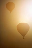 hermosa globos gratis volador en el atmósfera de dorado luz de sol en el cielo y globo noche resplandor en Tailandia internacional globo festival. foto