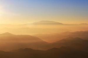Beautiful Sunset and sunrise on sky and golden twilight time with mist and fog in valley of mountain layer photo
