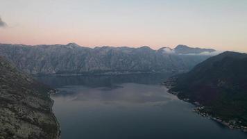 4k Antenne Aufnahmen von perast einer von das berühmt Tourist Städte von Montenegro beim Sonnenuntergang mit bunt Wolken reflektieren auf das Meer video