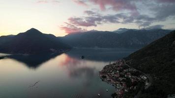 4k Antenne Aufnahmen von perast einer von das berühmt Tourist Städte von Montenegro beim Sonnenuntergang mit bunt Wolken reflektieren auf das Meer video