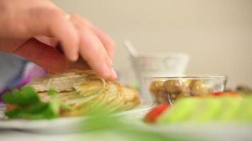 Businessman eating breakfast athome, food from toast and breakfast items on the table, selective focus video