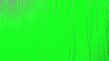 realistisk 3d regn falla effekt på glas med grön bakgrund. regn faller på glas grön skärm, regn droppar, slinga animering bakgrund av regn droppar faller video