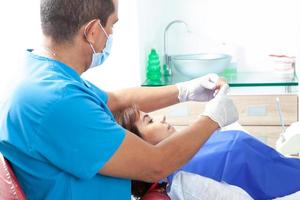 Beautiful woman receiving an orthodontic treatment at dentist office photo