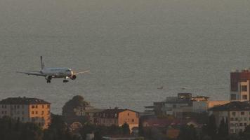 SOCHI, RUSSIA JULY 28, 2022 - Airplane of Ural Airlines landing at Sochi airport at sunset. Cinematic footage of the plane flies. Tourism and travel concept video