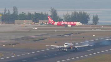 phuket, Tailândia fevereiro 23, 2023 - airbus A320 airásia avião pousar, tocante e travagem às phuket aeroporto, lado visualizar. avião em a taxiway. ásia baixo custo CIA aérea em a aeródromo video