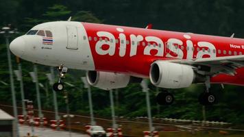 PHUKET, THAILAND DECEMBER 02, 2016 - Passenger plane low cost airline AirAsia landing on Phuket island, side view. Tourism and travel concept video