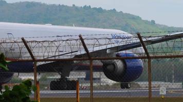 PHUKET, THAILAND JANUARY 30, 2023 - Widebody plane Boeing 777 of Aeroflot on the runway at Phuket airport, side view. Airliner ready to take off. Tourism travel concept video