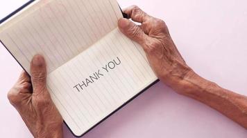 senior women's hand holding thank you note , top down video