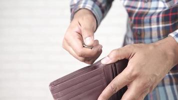 Close up of person hand putting coins in a wallet video