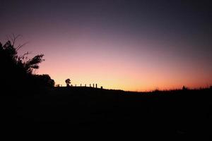 hermosa silueta de momentos en natural amanecer y puesta de sol en el montaña. paz, soledad y haloween concepto. foto