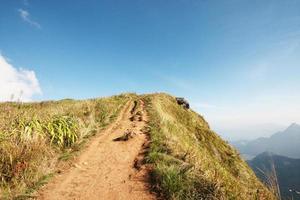 Natural footpath and dry grassland on the mountain with blue sky at Phu Chee Fah hill northern of Thailand photo