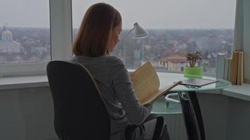 female reads old book in apartment video