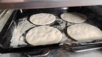 Round bread cakes are being baked in a home oven. video