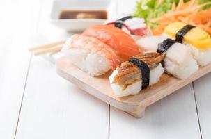 sushi with sauce and wasabi on wood plate photo