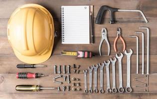 Set tools supplies with blank notebook on wood photo