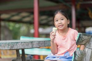 linda niña pequeña comiendo helado foto