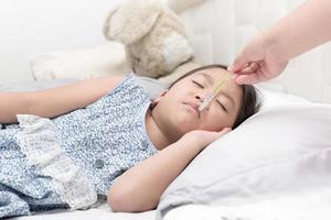 madre medición temperatura de su enfermo niño foto