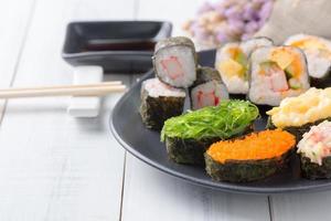 algas marinas Sushi en negro plato y blanco madera antecedentes foto