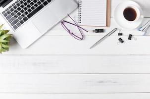 Modern white office desk table with laptop, photo