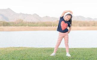 cute asian girl exercise on green grass photo