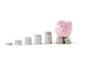 Pink piggy bank on coin isolated photo