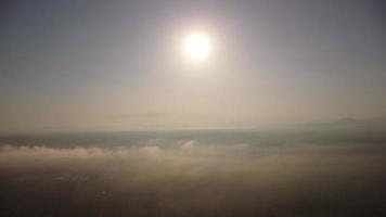 aéreo ver de tierras de cultivo en niebla con dorado luz de sol a amanecer en primavera. hermosa rural paisaje video