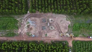 vista aérea del sitio de construcción de cimientos de pilón de alto voltaje. vista superior de la construcción de líneas eléctricas en el bosque. video