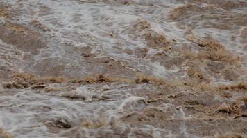 Waterfall cataract in forest mountains. Dirty streams are flowing down the mountain slopes of the mountain forest after heavy rains in Thailand. River flood, selective focus. video