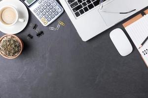 Office black desk table with calculator, paper note, supplies photo