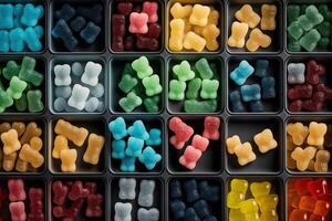 illustration of vast array of different gummy bear flavors in open square containers photo