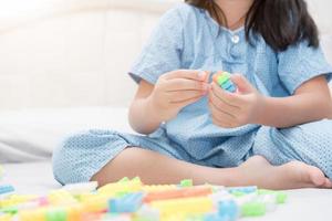 niña jugar bloquear ladrillos en cama, educación foto