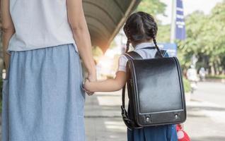 Mother's hand lead his child daughter go to school photo