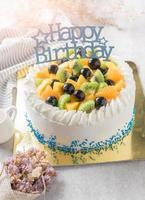 Mix fruits Kiwi orange and grape on cream cake photo