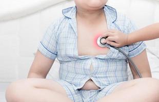 doctor check heart by stethoscope to obese asian boy photo