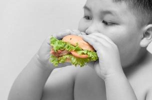 hamburger on obese boy hand Black and white background photo
