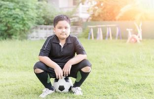obese fat boy soccer player sit on football photo