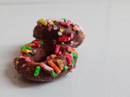 Close up of glazed doughnuts with bright colored sprinkles,isolated on a white background. photo