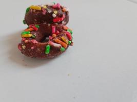 cerca arriba de vidriado rosquillas con brillante de colores rocía,aislado en un blanco antecedentes. foto