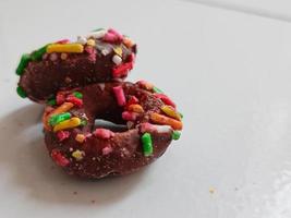 Close up of glazed doughnuts with bright colored sprinkles,isolated on a white background. photo