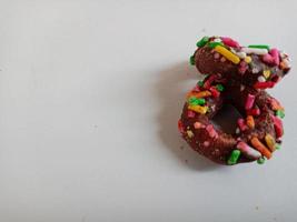 cerca arriba de vidriado rosquillas con brillante de colores rocía,aislado en un blanco antecedentes. foto